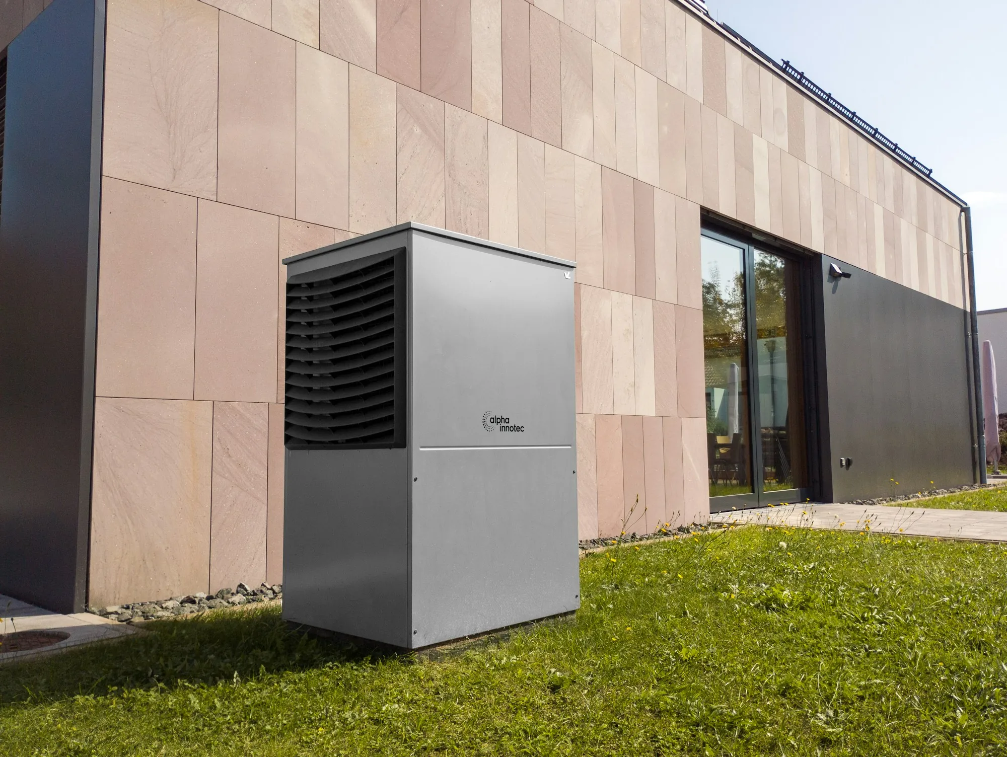 Air source heat pump on a lawn beside a modern building